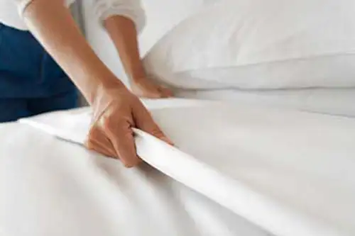 Person changing the sheets on a bed - Florida Pest Control, Gainesville FL