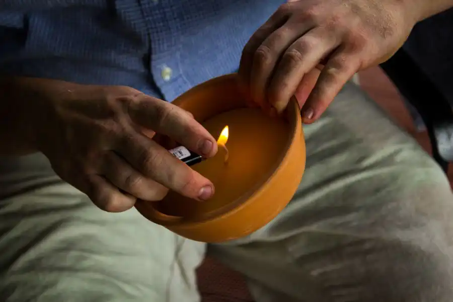 A person lighting a citronella candle outside - Keep mosquitoes away from your home with Florida Pest Control in Gainesville FL