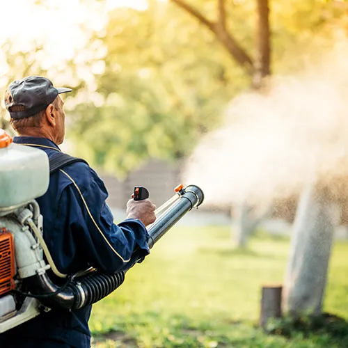 Pest control technician spreading pest treatment on a lawn - Keep pests away from your home with Florida Pest Control